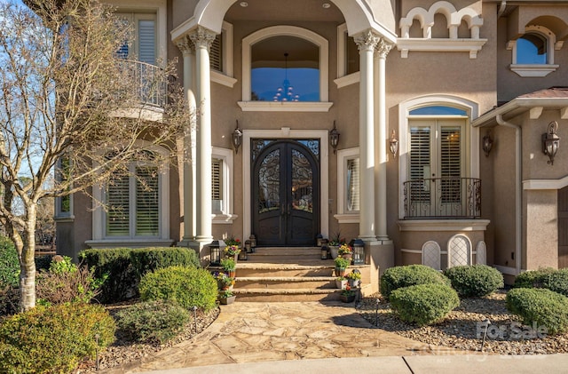 property entrance featuring french doors and stucco siding