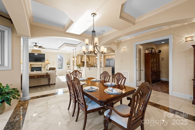 dining room featuring visible vents, baseboards, ornamental molding, a fireplace, and ornate columns