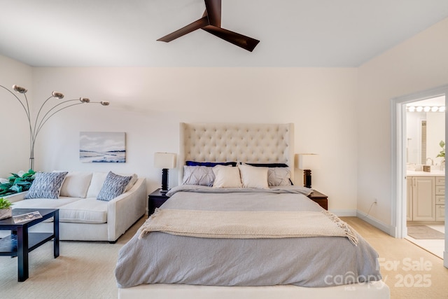 bedroom with ensuite bathroom, baseboards, a ceiling fan, and light carpet