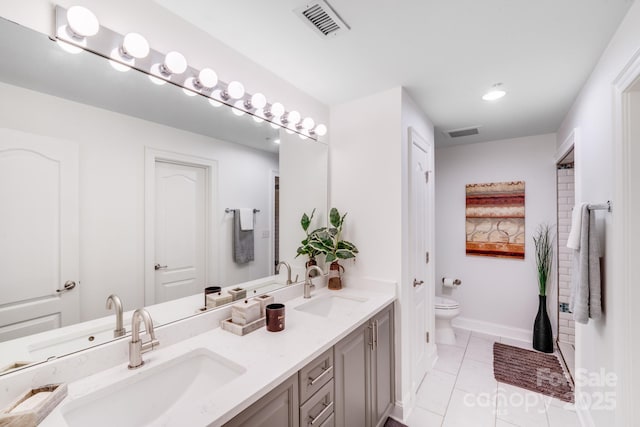 bathroom featuring toilet, a sink, and visible vents