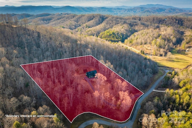 aerial view with a mountain view and a wooded view