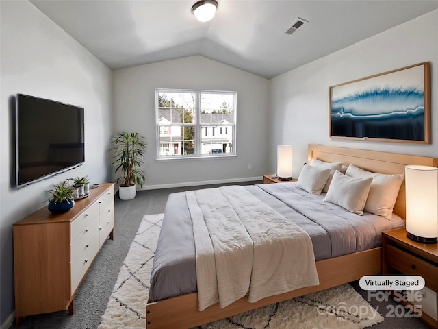 bedroom with dark colored carpet and lofted ceiling