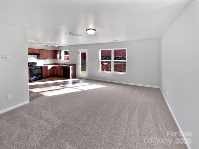 unfurnished living room with sink and carpet floors