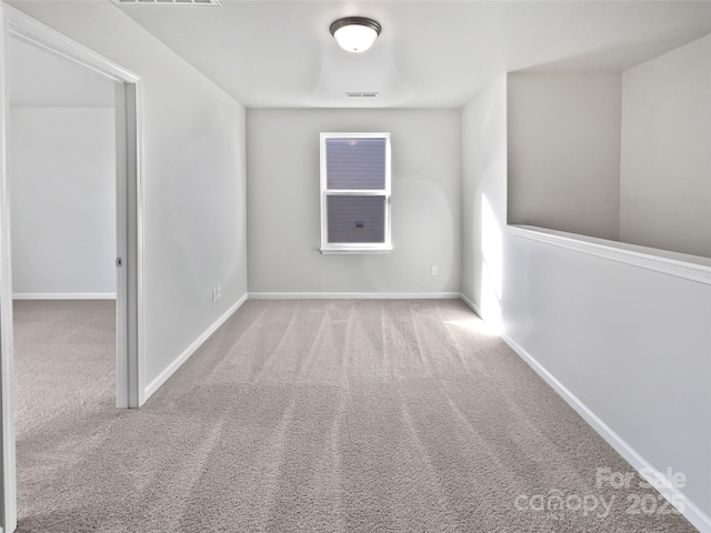 unfurnished room featuring light colored carpet