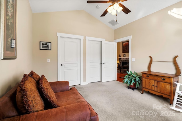 carpeted living room with ceiling fan and lofted ceiling