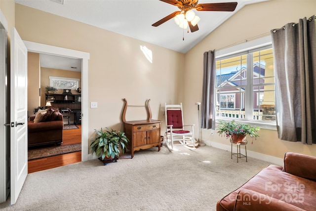 sitting room with lofted ceiling, light colored carpet, and ceiling fan