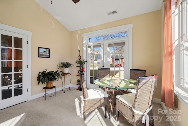 carpeted dining room with lofted ceiling, french doors, and ceiling fan