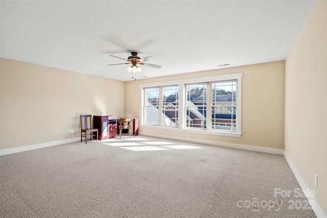 interior space featuring ceiling fan, light carpet, and a textured ceiling