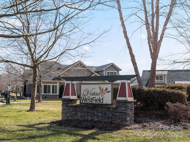 community sign featuring a yard