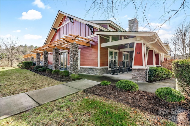 view of front of house with a front yard and a pergola