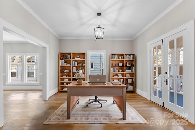 home office with ornamental molding, light hardwood / wood-style floors, french doors, and a chandelier