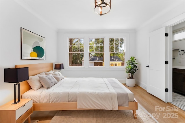 bedroom featuring ornamental molding and light hardwood / wood-style floors