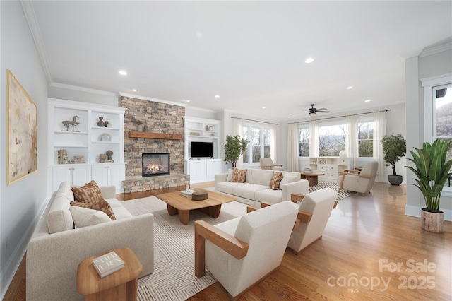 living room with crown molding, plenty of natural light, a fireplace, and light hardwood / wood-style floors