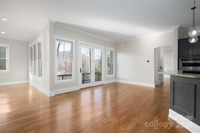 unfurnished living room featuring hardwood / wood-style flooring and crown molding