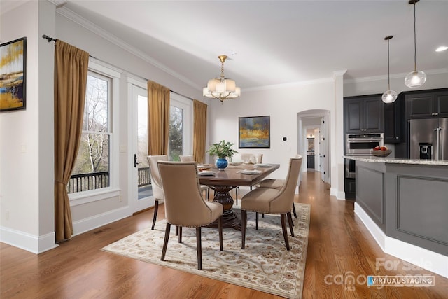 dining area with crown molding, dark wood-type flooring, and an inviting chandelier