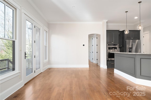 kitchen with pendant lighting, light stone counters, light hardwood / wood-style flooring, and appliances with stainless steel finishes