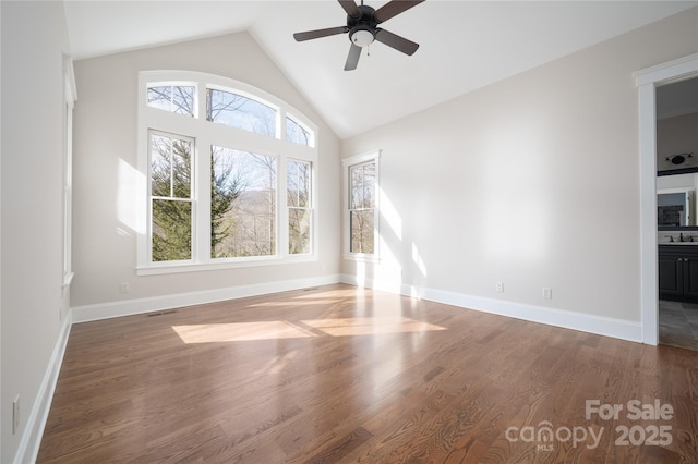 interior space featuring dark wood-type flooring, ceiling fan, sink, and high vaulted ceiling