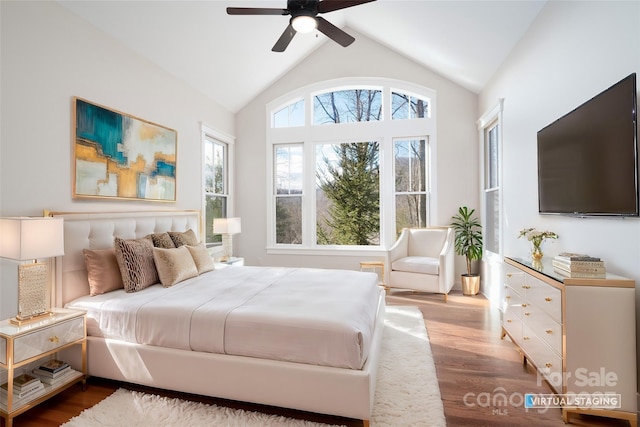 bedroom with ceiling fan, wood-type flooring, and high vaulted ceiling