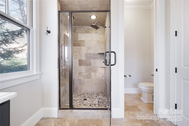 bathroom with walk in shower, ornamental molding, a healthy amount of sunlight, and toilet