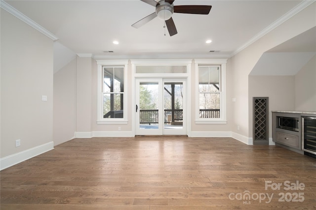 unfurnished living room with hardwood / wood-style flooring, ceiling fan, and ornamental molding