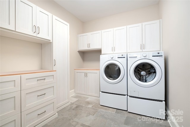 laundry area with washing machine and dryer and cabinets