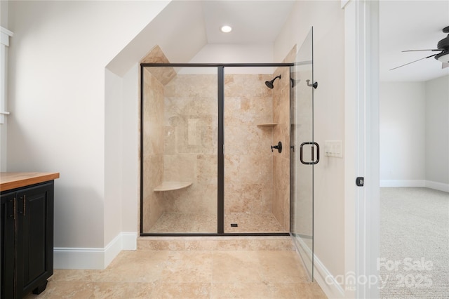 bathroom featuring ceiling fan and a shower with door