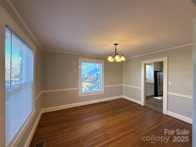 unfurnished room featuring an inviting chandelier, dark hardwood / wood-style floors, and crown molding