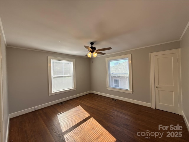 unfurnished room featuring dark wood-type flooring, ornamental molding, and ceiling fan