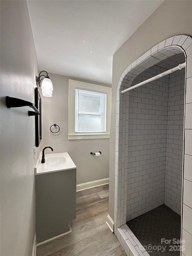 bathroom with vanity, wood-type flooring, and tiled shower