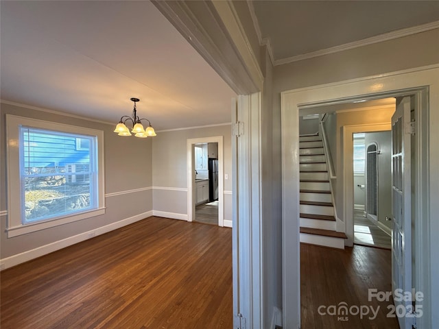 interior space with dark hardwood / wood-style flooring, crown molding, and an inviting chandelier