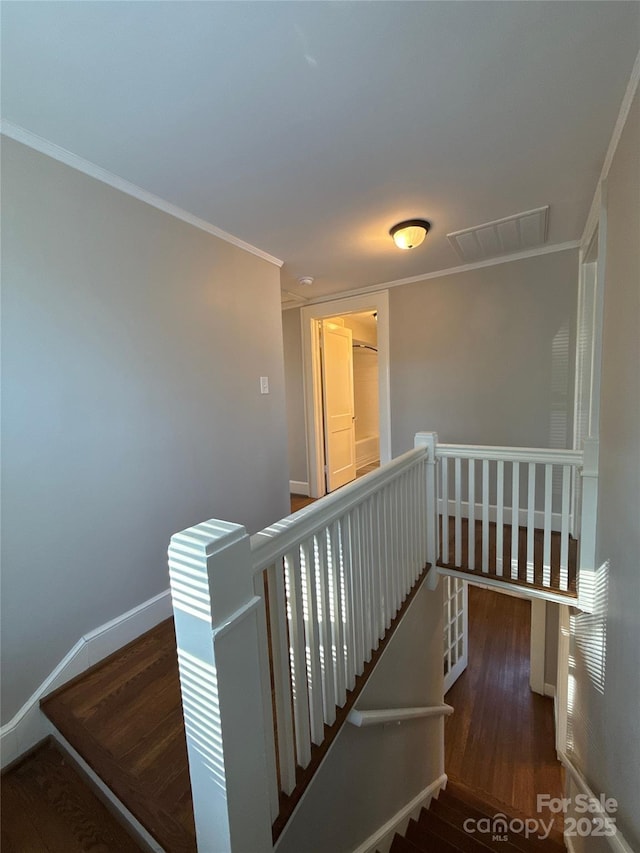 staircase featuring crown molding and wood-type flooring