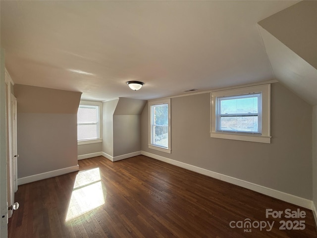 bonus room featuring plenty of natural light, lofted ceiling, and dark hardwood / wood-style flooring