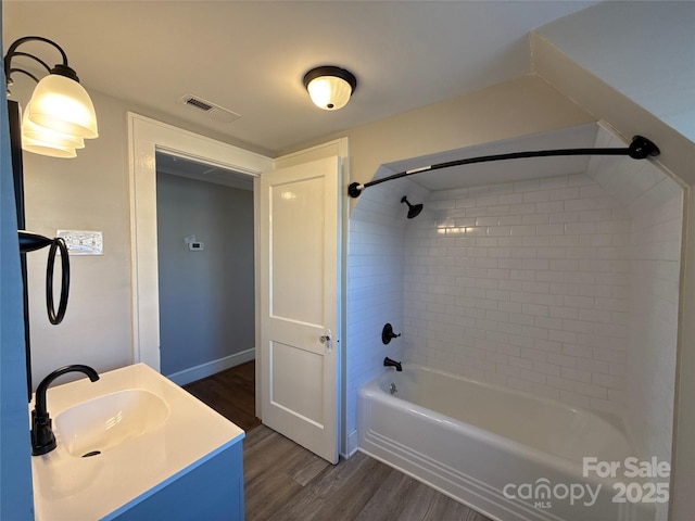 bathroom with vanity, tiled shower / bath combo, and hardwood / wood-style floors