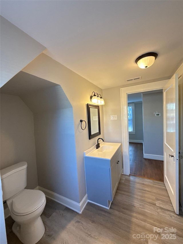 bathroom with vanity, wood-type flooring, and toilet