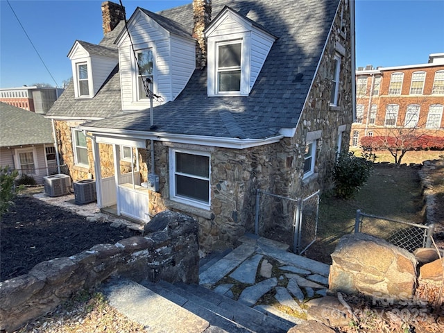 rear view of house featuring central AC