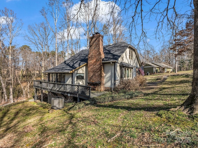 view of side of home featuring a yard and a deck