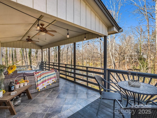 sunroom / solarium featuring ceiling fan, lofted ceiling, and a wealth of natural light