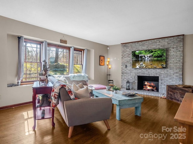 living room with wood-type flooring and a brick fireplace