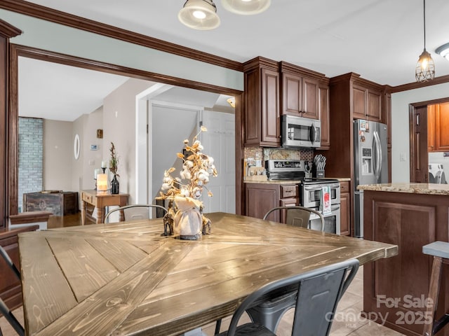 dining area with light tile patterned flooring and crown molding