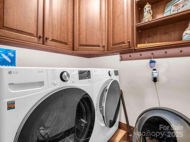 laundry room with cabinets and washing machine and clothes dryer