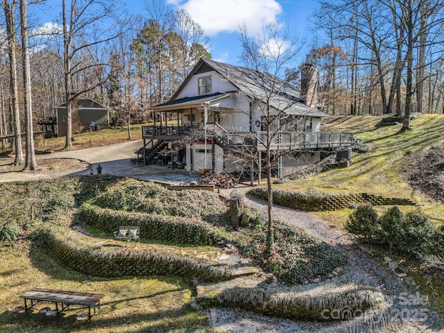 view of side of property featuring a garage, a deck, and a lawn