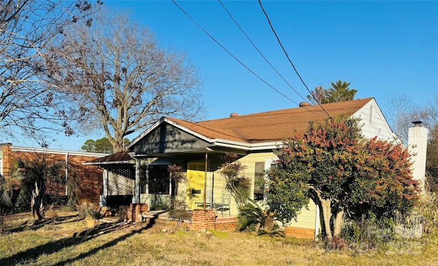 bungalow with a front lawn and covered porch