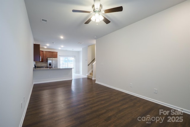 unfurnished living room featuring dark hardwood / wood-style floors and ceiling fan