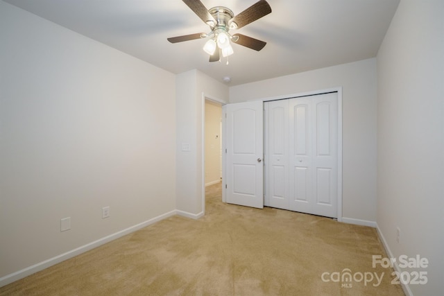 unfurnished bedroom with light carpet, a closet, and ceiling fan