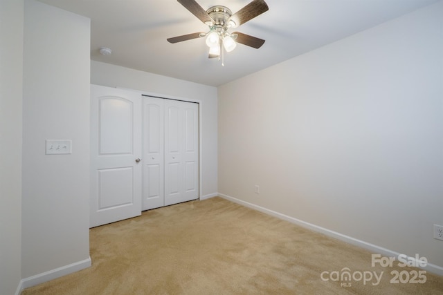 unfurnished bedroom with light carpet, ceiling fan, and a closet