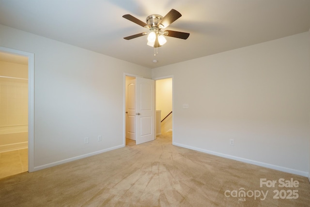 unfurnished bedroom featuring ceiling fan, ensuite bath, and light carpet