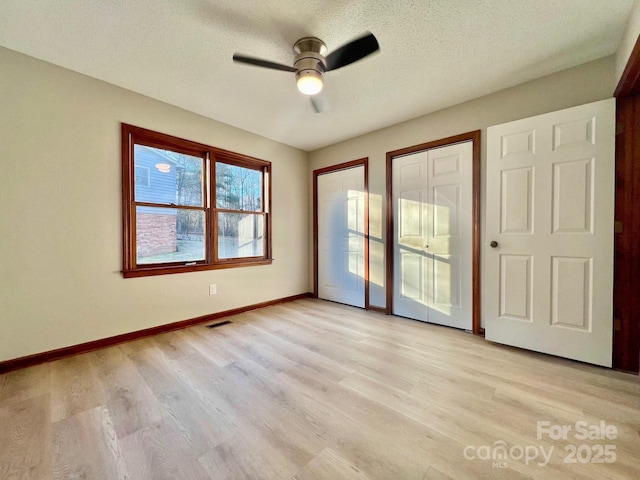 interior space featuring ceiling fan, light hardwood / wood-style flooring, and a textured ceiling