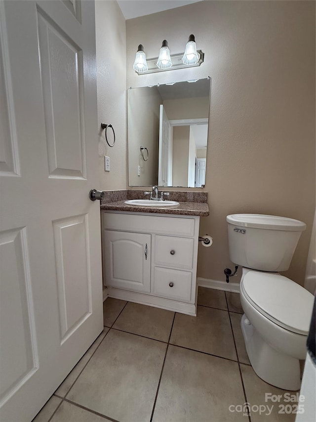 bathroom featuring vanity, tile patterned floors, and toilet