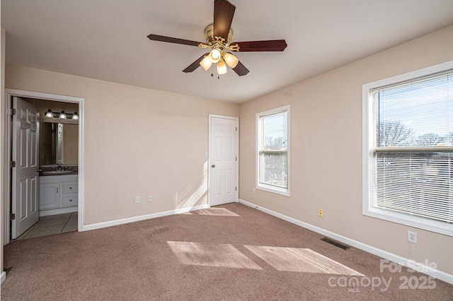 unfurnished bedroom with ceiling fan, ensuite bathroom, carpet flooring, and sink