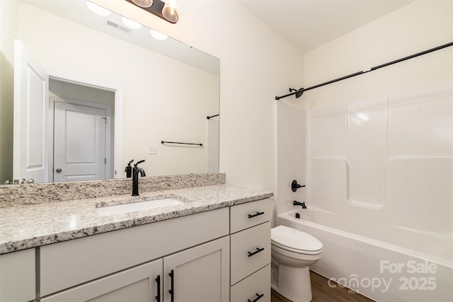 full bathroom featuring hardwood / wood-style flooring, vanity, toilet, and shower / bath combination